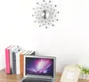 A wall clock and a laptop are on a desk with books. Podgląd zdjęcia produktu