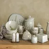 A collection of ceramic tableware with a lavender and fern motif, arranged on a wooden surface. Produktbild-Vorschau