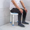A person sitting on a shower stool in a bathroom. Produktbild-Vorschau