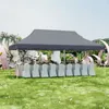 An outdoor event setup with a gray canopy tent, tables, and chairs covered in white cloths, decorated with floral arrangements and large pink decorative elements. Anteprima dell’immagine prodotto