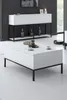 A modern living room setting with a white coffee table and a white console table against a dark ribbed wall. Produktbild-Vorschau