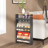 A narrow shelving unit filled with various items, placed next to a sofa. Náhľad obrázku produktu