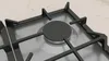 A close-up view of a gas hob burner with its cast iron grate. Produktbild-Vorschau