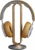 A pair of headphones rests on a wooden stand. Produktbild-Vorschau