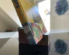 A book is propped up on a wooden stand on a reflective surface, with a bright window in the background. Produktbild-Vorschau