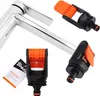 A chrome faucet with two black and orange hose connectors, one with a tag attached. Voir les images du produit
