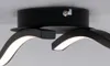 A close-up view of a modern black LED ceiling light fixture with curved arms. Produktbild-Vorschau