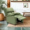 A green recliner chair is shown in a living room setting with a plant and a wooden bench in the background. Voir les images du produit