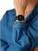 A person wearing a denim jacket and a black digital watch. Anteprima dell’immagine prodotto