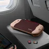 A Nintendo Switch case is placed on an airplane tray table, with a game cartridge next to it. Produktbild-Vorschau