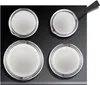 Four round metal pots with white interiors are arranged on a black surface. One pot has a black handle attached. Anteprima dell’immagine prodotto