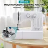 A white multifunctional sewing machine is displayed on a wooden table with a blurred background of a window and plants. Produktbild-Vorschau