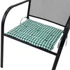 A close-up shot of a green and white checkered cushion on a black metal chair. Produktbild-Vorschau