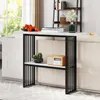 A console table with two shelves is placed behind a sofa, with decorative items on it. Produktbild-Vorschau