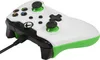 A close-up, angled view of a white and green Xbox controller with a black cable plugged in. Voir les images du produit