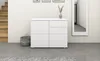 A white dresser with drawers and doors stands against a white wall, next to a staircase and a large mirror. A woven basket sits on the floor beside the dresser. Produktbild-Vorschau