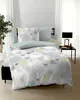 A bed with bedding featuring a forest and deer pattern, set in a bedroom with a plant and a bedside table with a lamp. Produktbild-Vorschau