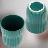 Two turquoise ceramic pots are shown against a light gray and white background. One pot is shown from the side, and the other is shown from the top, revealing its interior. Voir les images du produit