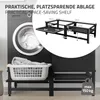 A washing machine and a black metal shelving unit designed to fit over it, with dimensions indicated. Podgląd zdjęcia produktu
