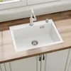 A white kitchen sink with a white faucet and soap dispenser, installed on a wooden countertop. Podgląd zdjęcia produktu