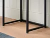 Close-up view of the black metal legs of a console table resting on a light wooden floor, with a white paneled wall in the background. Produktbild-Vorschau