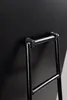 A close-up view of the back of a black frame with a silver metal support. Produktbild-Vorschau