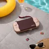 A Nintendo Switch case and accessories are placed on a poolside patio. Produktbild-Vorschau
