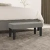 A grey bench sits in front of a bed with white bedding. Náhľad obrázku produktu