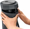 Hands operating a gray appliance. Anteprima dell’immagine prodotto