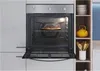 An open oven with a pizza inside, set in a modern kitchen environment with shelving on the right. Voir les images du produit