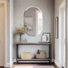 A hallway with a console table, mirror, and decorative items. Voir les images du produit