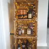 A stack of wooden crates filled with bottles of alcohol, decorated with fairy lights. Náhled obrázku produktu