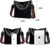 Product image showing a black handbag with dimensions indicated, and also showing the handbag with a smartphone and a tablet for scale. Náhľad obrázku produktu