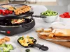 A raclette grill set up with food, including skewers of meat, vegetables, cheese, and bread, on a table. Anteprima dell’immagine prodotto
