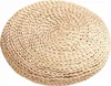 A round woven cushion on a white background. Produktbild-Vorschau