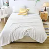 A white blanket is draped over a bed, with a yellow and white striped pillow on top. Náhled obrázku produktu