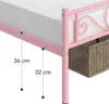 Close-up of a pink metal bed frame with a woven storage basket underneath. Produktbild-Vorschau