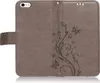 A gray flip case for a smartphone, with a floral and butterfly embossed design. Produktbild-Vorschau