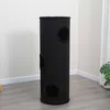 A tall, black, cylindrical cat scratching post with three circular openings is shown in a room with light gray flooring and white walls. Produktbild-Vorschau