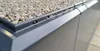 Close-up view of a roof edge with gravel and a gray profile. Produktbild-Vorschau