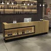 A bar counter with bottles displayed on shelves and in a lit compartment. Produktbild-Vorschau