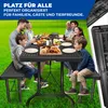 A family and friends enjoying a picnic or barbecue outdoors at a table with benches. Produktbild-Vorschau