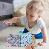 A baby is playing with a soft fabric book on the floor. Anteprima dell’immagine prodotto