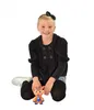 A young girl is kneeling on the floor with a toy. Voir les images du produit