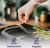A person's hand is holding a lid over a baking dish containing asparagus. Náhľad obrázku produktu