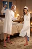 A couple in matching nightgowns and hats are dancing in a bedroom at night. Produktbild-Vorschau