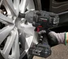 A person is using a cordless impact wrench to tighten a lug nut on a car wheel. Produktbild-Vorschau