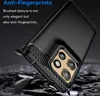A black smartphone case with a carbon fiber texture on the sides and a brushed metal texture on the back, shown at an angle against a dark, rocky background. Produktbild-Vorschau