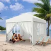 A white gazebo tent set up on a sandy beach with people relaxing inside and two deck chairs outside. Voir les images du produit