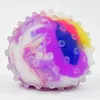 A close-up studio shot of a colorful stress ball with raised bumps. Produktbild-Vorschau